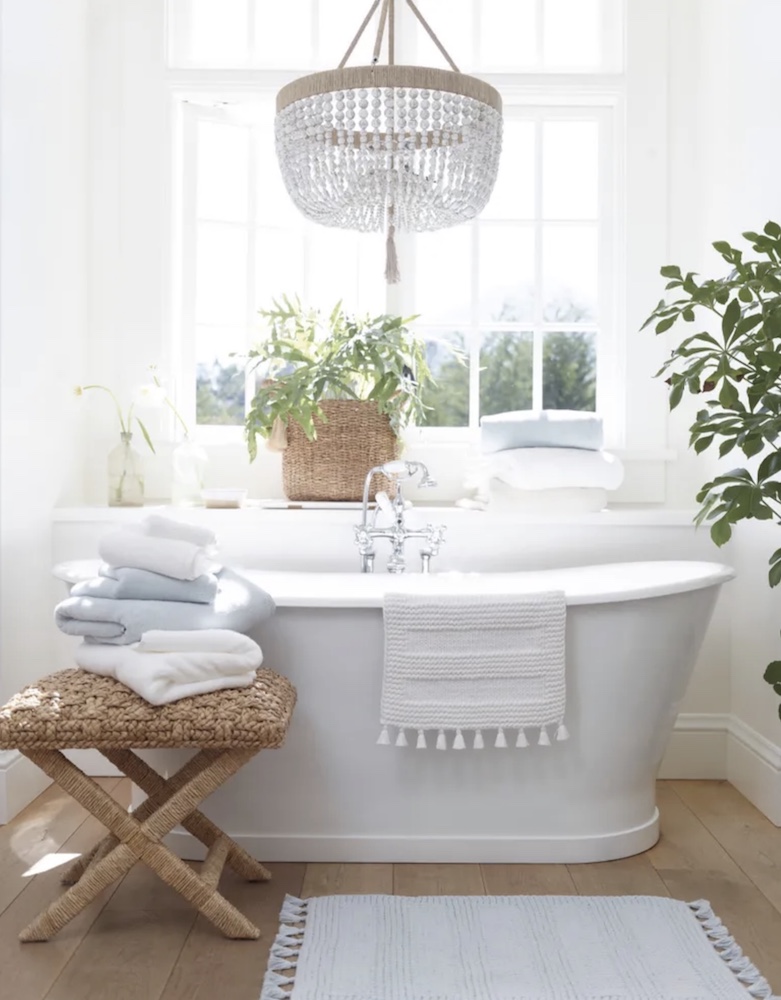A woven stool can provide seating or surface space in a bathroom where it can hold towels near the tub.

Serena & Lily